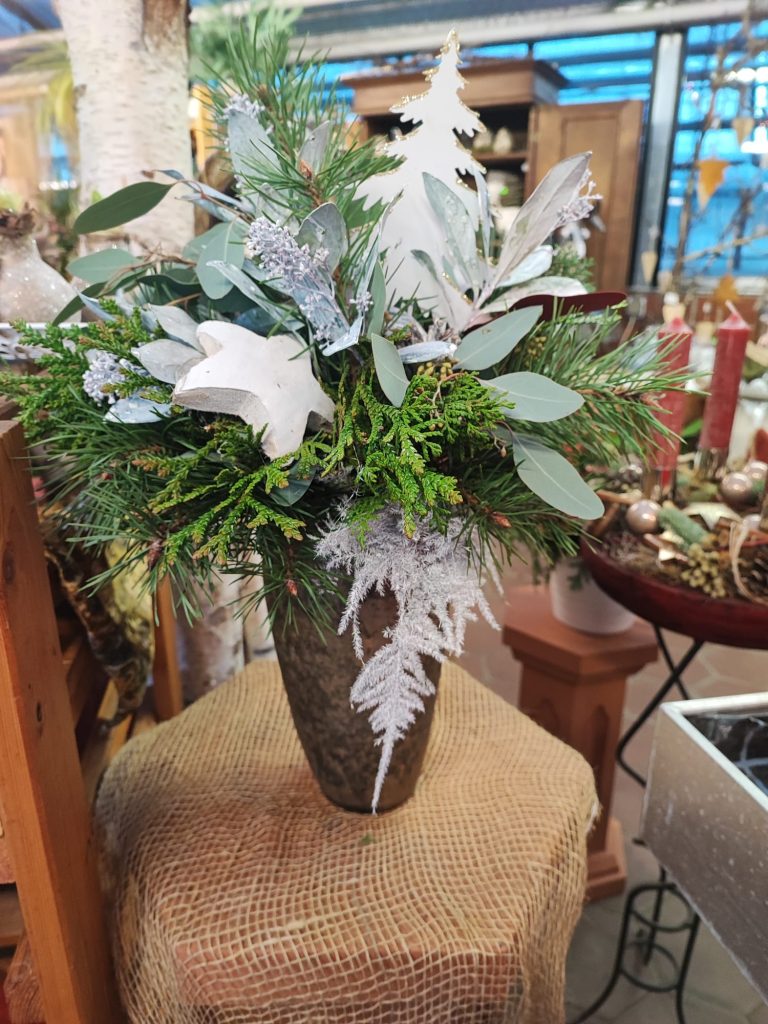 Weihnachtsgesteck mit weißer Dekoration in Vase